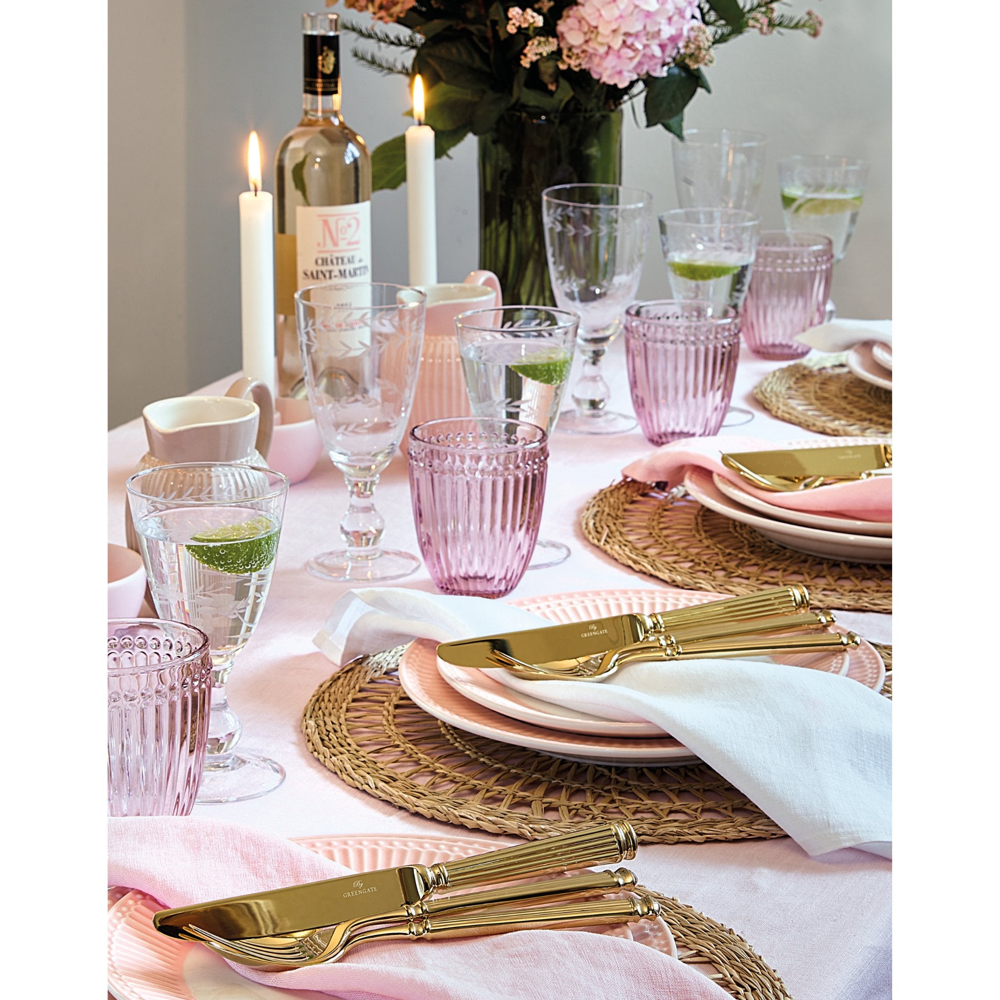 Goldbesteck von GreenGate, bestehend aus Messer und Gabel, stilvoll auf einem Esstisch arrangiert.