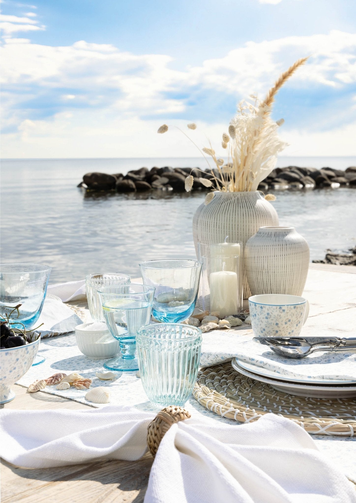 Weingläser GreenGate hellblau auf Strandtisch am Meer