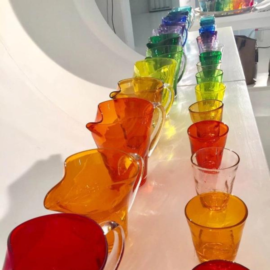 Trinkgläser und Krüge der gleichen Kollektion in allen Farbkombinationen, nebeneinander aufgereiht