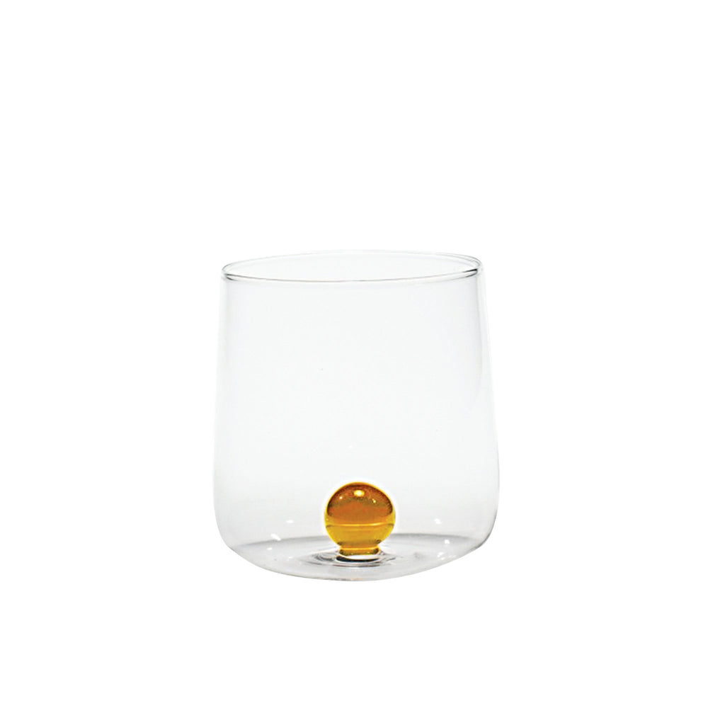 Trinkglas transparent mit goldgelber Murmel im Inneren