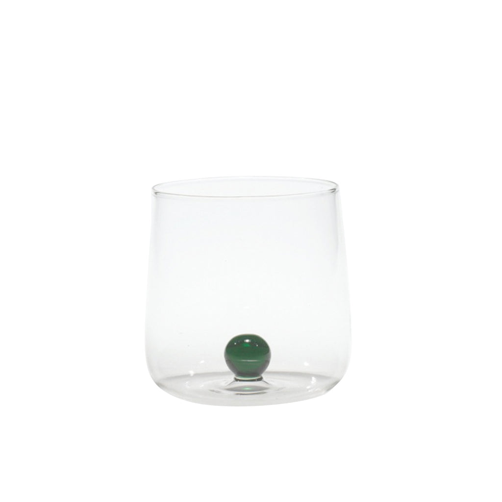 Trinkglas transparent mit grüner Murmel im Inneren