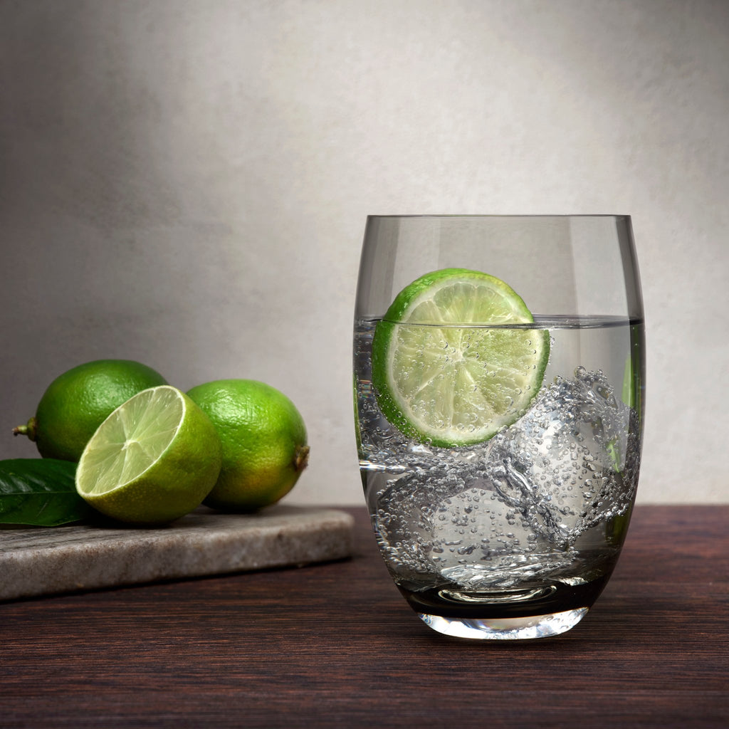 Trinkglas grau mit Wasser und Scheibe Limette gefüllt