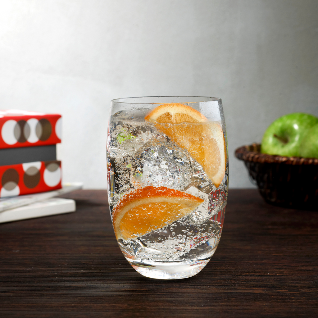 Trinkglas grau mit Wasser und zwei Scheiben Orange gefüllt
