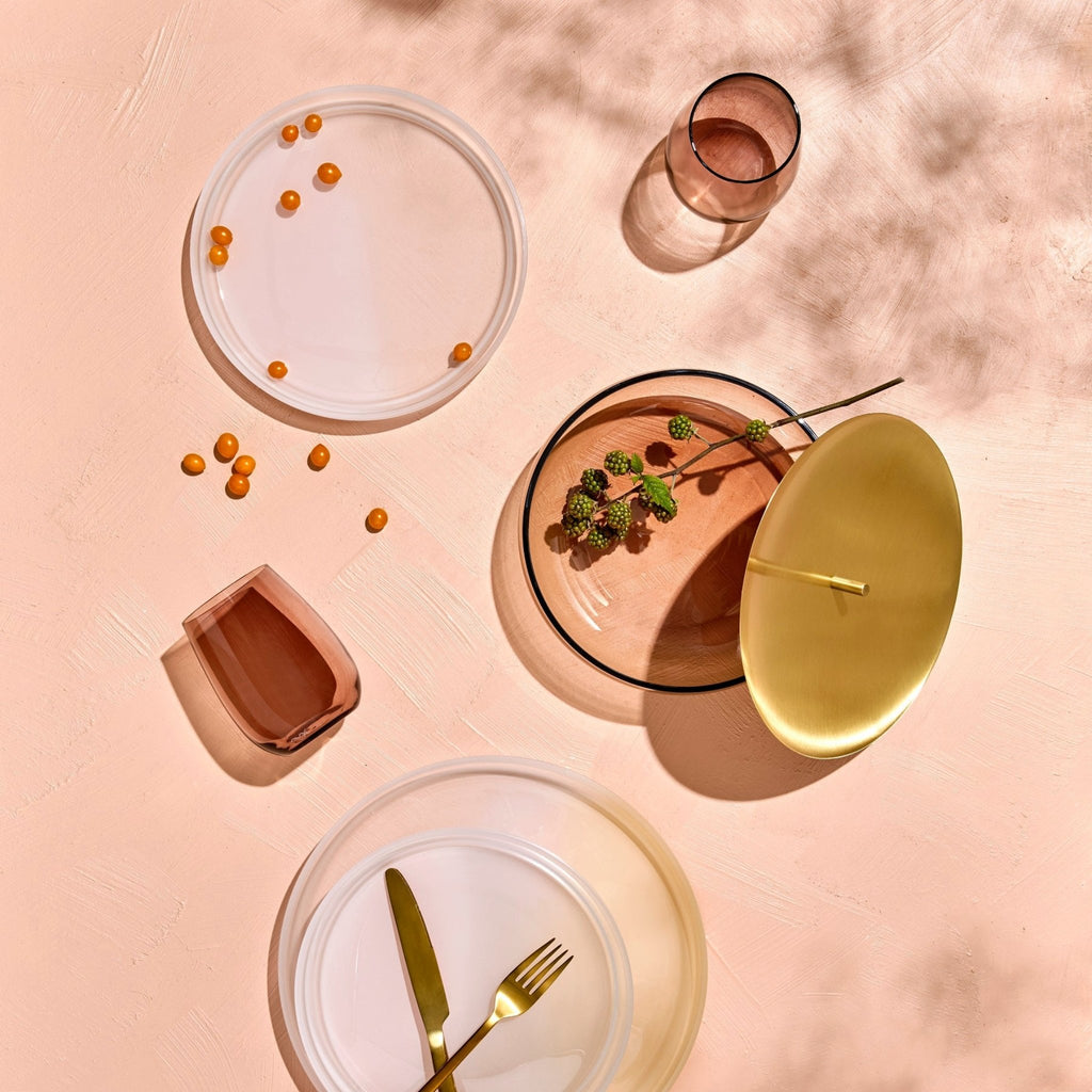 Trinkgläser in transparent, caramel mit Wasser gefüllt auf einem gedeckten Tisch stehend
